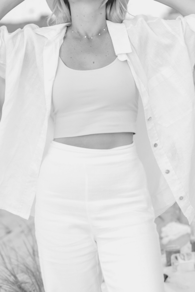 Black and white image of Hollie on beach wearing white