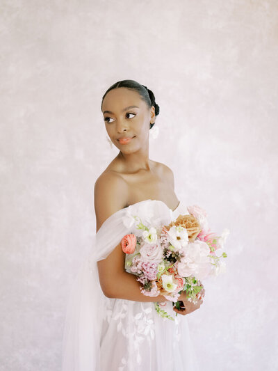 Elopement Photographer, a bride in a dress stands before a garden of flowers