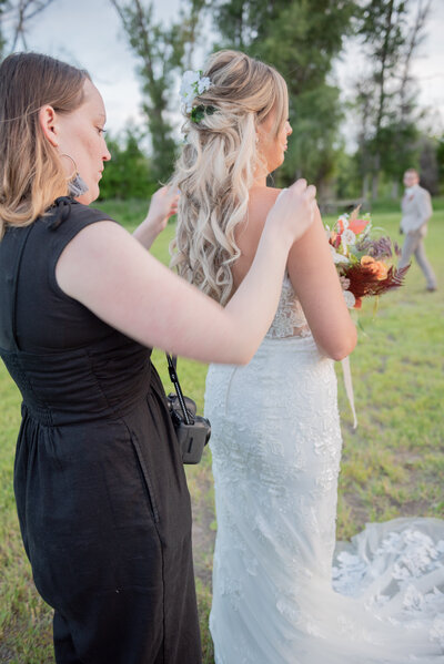 Seattle Wedding Planner fixing brides dress for wedding photos
