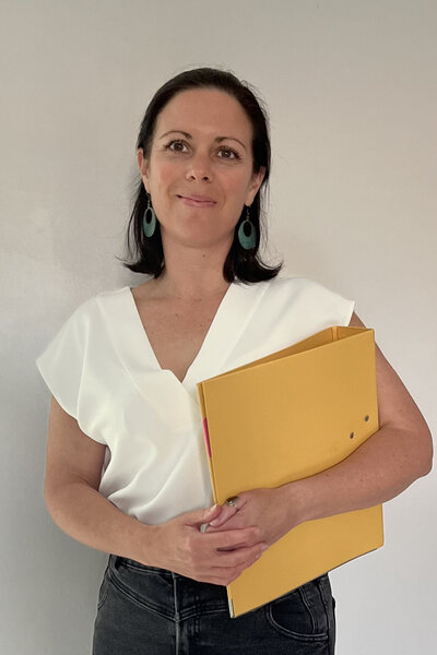 Photo portrait de Caroline Kerhom-Nookala tenant une pochette de documents