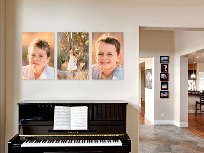Headshot photo prints hanging above a black piano in a family room