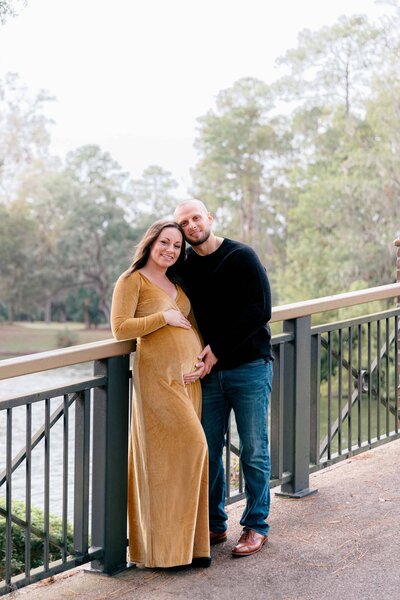 Man touching wife’s belly during maternity session for Palmetto Bluff photographer Lamp and Light Photography.