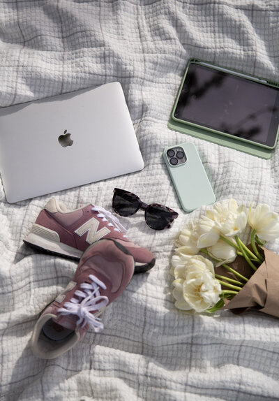 Graphic, web and branding designer Bess Brownlee with her laptop, iPad, iPhone and flowers outside in Missoula, Montana.