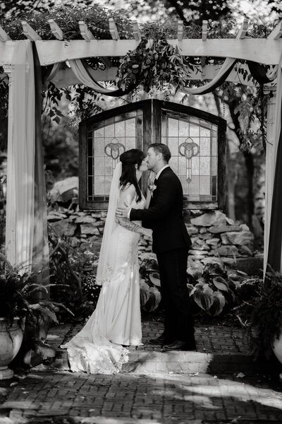 black and white wedding ceremony kiss