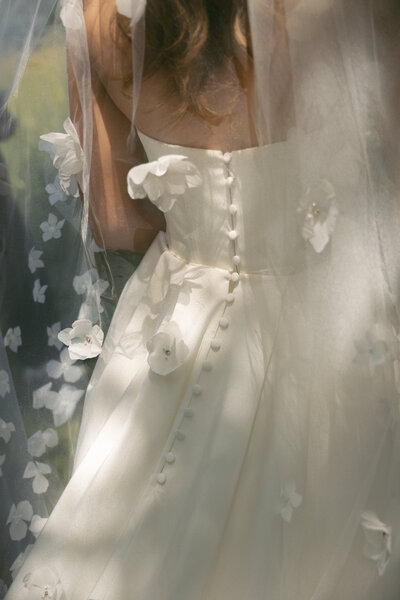 Photo of bride walking towards wedding guests looking back at the camera