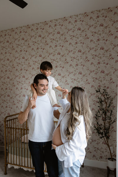 indoor maternity image in nursery room of family of 3