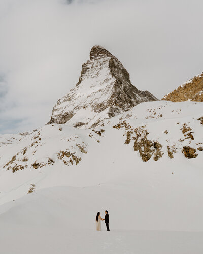 bride and groom running on beach cliff