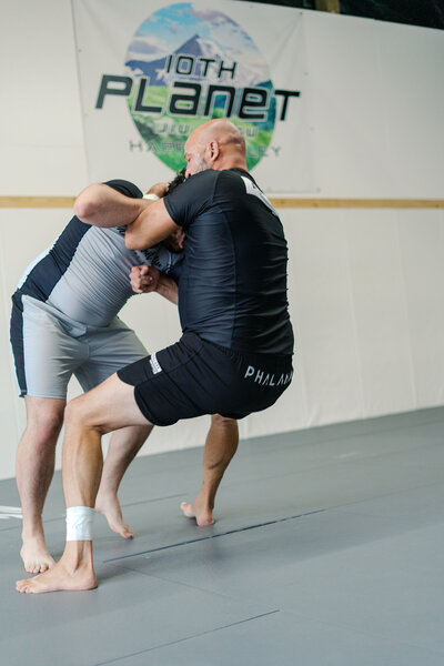 Two male Brazilian Jiu-jitsu athletes grappling during no-gi training at 10th Planey Portland Gym