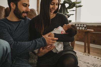 woman and man looking at baby and smiling