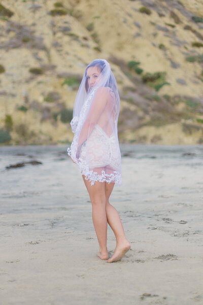 Future bride in lace lingerie  standing on beach