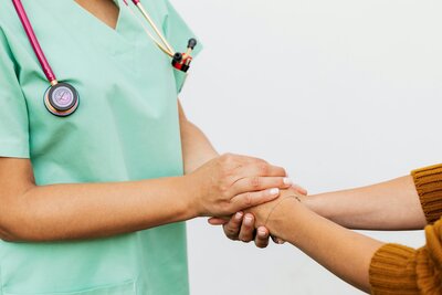 doctor and patient holding hands