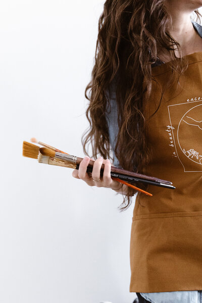 woman holding paintbrushes