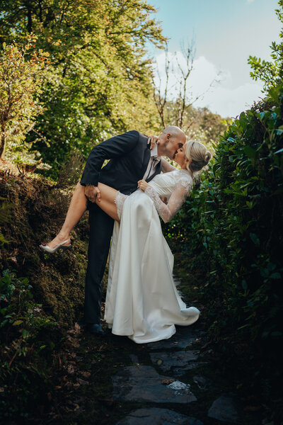 Bride & Groom sit together smiling under tree