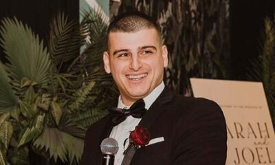 Wedding MC in formal attire speaking with a smile during a wedding reception speech