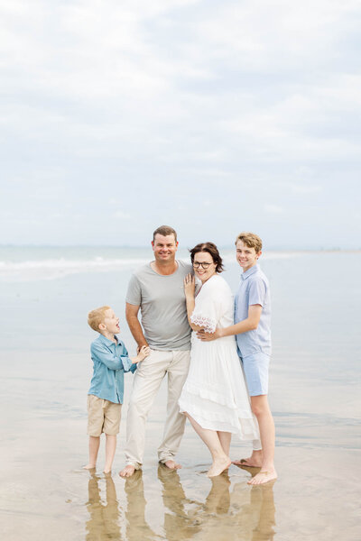 A sweet family standing for their family photo by Airlie Beach Photographer