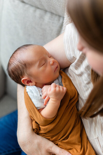 mom holding baby and snuggling during newborn photos