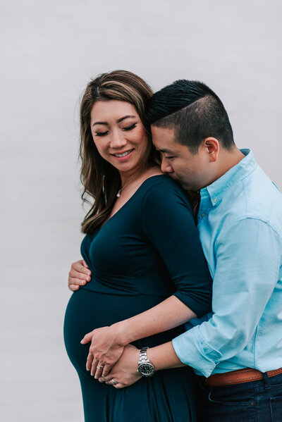 a sweet moment between husband and wife during their maternity session
