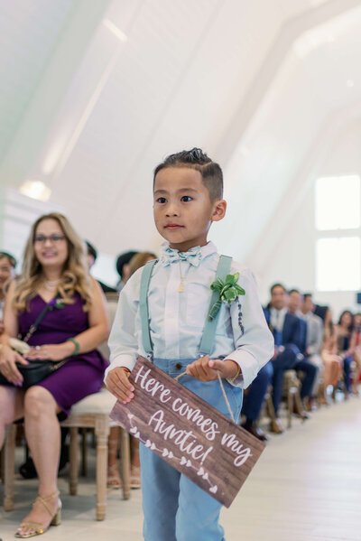 Image of a little boy holding a wedding signage inside the Etre Farms