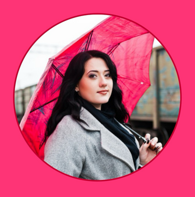 Headshot of indie author holding a pink umbrella outside in the fall