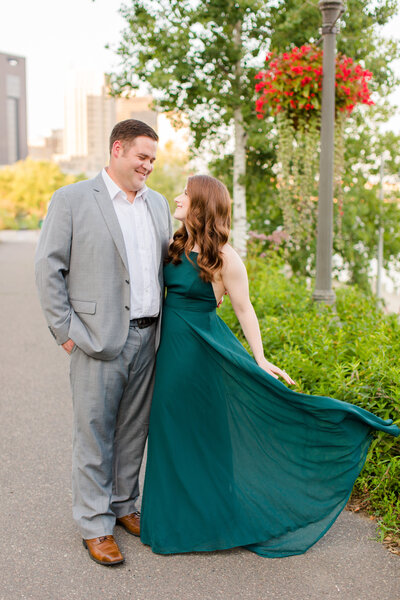 Bride and groom taking engagement pictures in emerald green dress