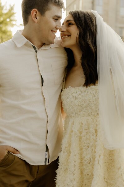 A couple has their faces close as they walk together.