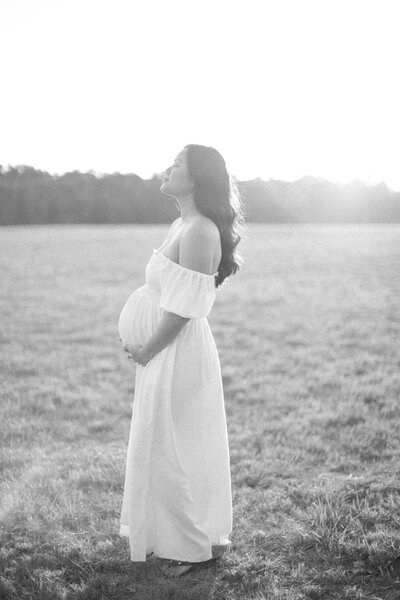 Mother standing, holding her pregnant belly
