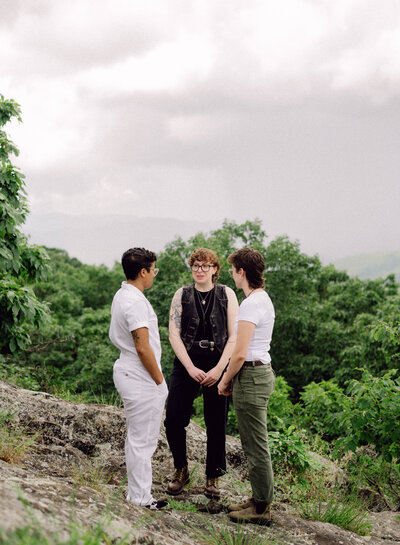 Cinematic wide shot of the couple embracing on the summit, with soft focus and natural light.
