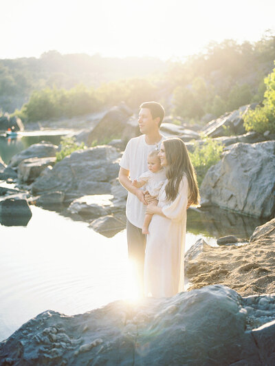 A family stands along the rocky beach in Great Falls, photographed by Northern VA Family Photographer Marie Elizabeth Photography.