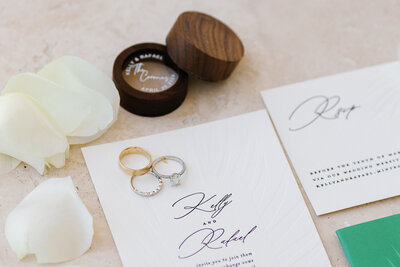 Elegant wedding invitation suite with gold rings at La Siesta Marina, captured by Claudia Amalia Wedding Photography.