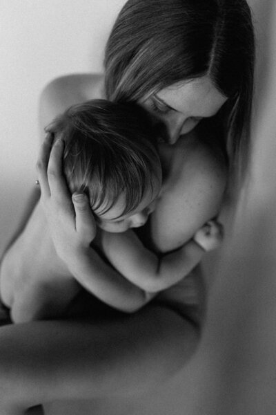 Mother and baby cozy and nursing for motherhood photoshoot