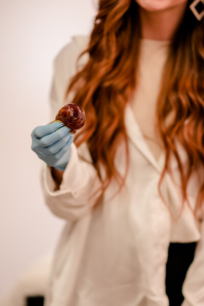 A group of three bridesmaids smile into the camera in a sun drenched space