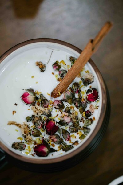 A warm, creamy milk latte infused with dried rose petals and cinnamon, creating a soothing and aromatic wellness drink.