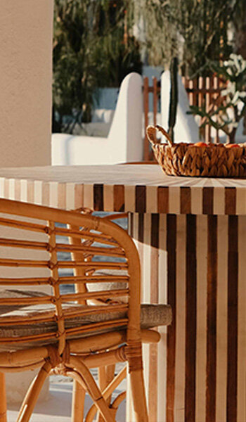 acapulco chair on gravel floor next to cream wall