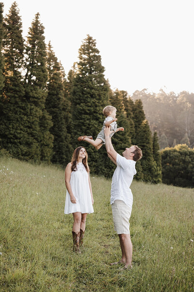 dad holding newborn with toddler