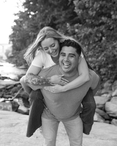 couple doing a piggyback ride during their sunrise engagement photos at Belle Isle in Richmond