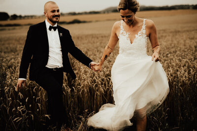 wedding couple walks on field during portraits in halmstad