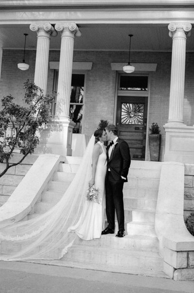 Black and white photo  of wedding heels, champagne, and napkins laying on a table