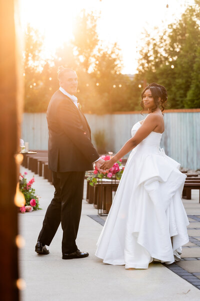 Experience the infectious joy of Sandy's laughter in this charming photo where she holds her stunning bridal bouquet. This image captures a candid, uplifting moment of the bride, her smile radiating as brightly as the beautiful bouquet she cradles. The combination of vibrant flowers and genuine happiness makes this picture a perfect snapshot of a memorable wedding day. Ideal for brides seeking inspiration for their wedding photography, this image showcases how spontaneous laughter and personalized floral arrangements can enhance the beauty of your special day.