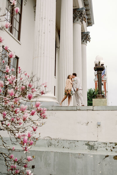 Bride and groom kissing on courthouse steps, intimate Wilmington courthouse wedding photography