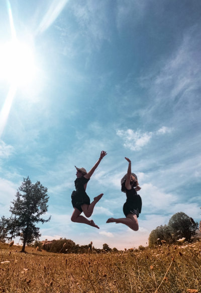 Francesca e Giulia ritratte in una foto insieme mentre saltano nella natura