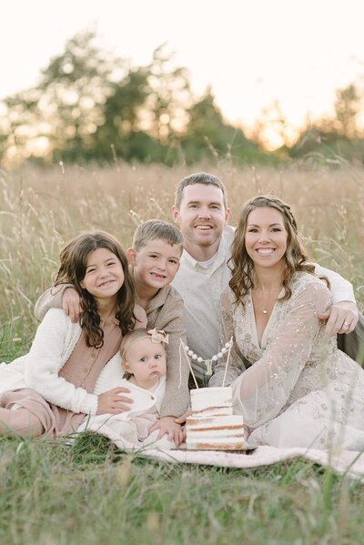 A family of five sits in a big field for family photos during the golden hour by Nashville Family Photographer Dolly DeLong Photography The Waddell Family
