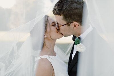 wedding couple kissing underneath veil
