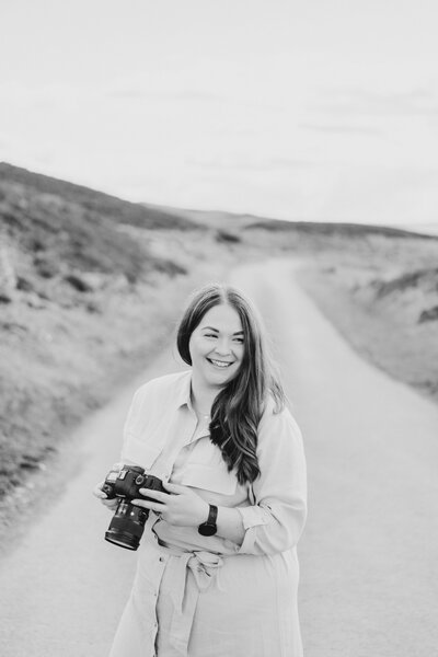 Sophie Siddons holding a camera in black and white