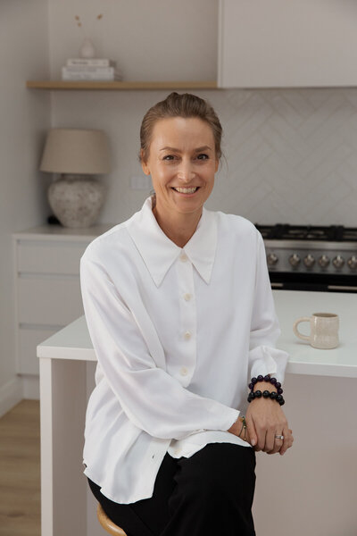 Auckland based Naturopath Lauren Glucina enjoying a cup of tea at the kitchen bench.