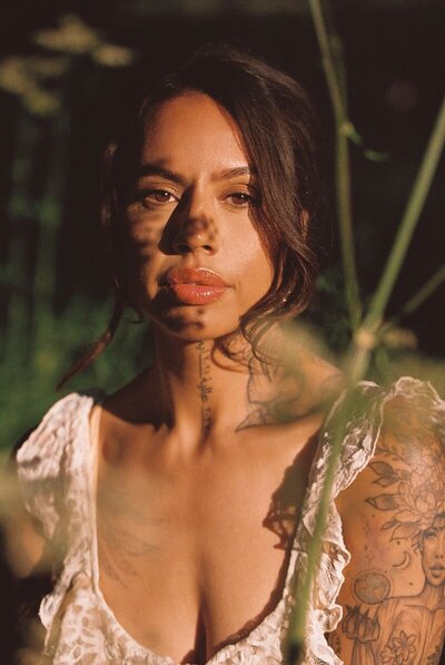 Close-up portret van een vrouw met schaduwpatronen op haar gezicht in natuurlijk licht.