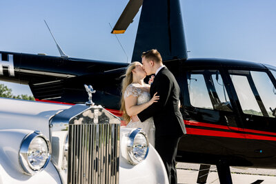 Bride and Groom kissing in front of a helicopter after their wedding at The Tate House