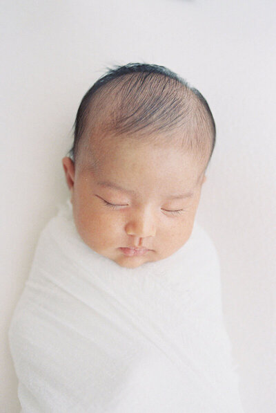 Baby sleeping and swaddled by Bay Area newborn photographer Laurel Smith.