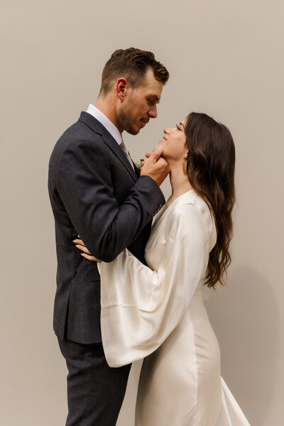 bride and groom looking at each other while groom touches bride's face