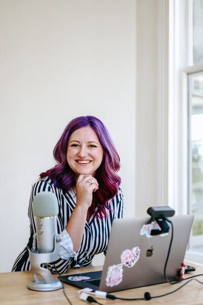 Photography Business Coach | Karinda K | Karinda with a laptop and microphone