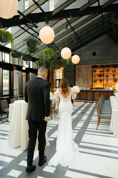 couple walking in atrium wedding